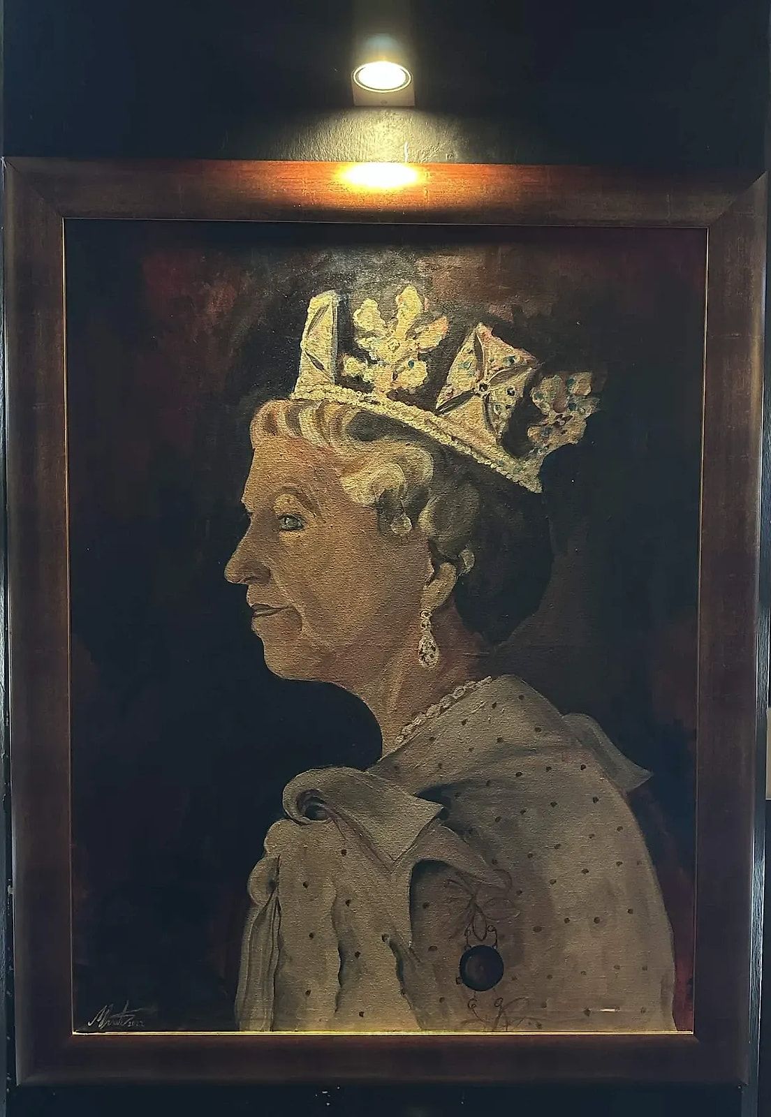 Uramljen portret u ulju na zidu, osvijetljen lampom